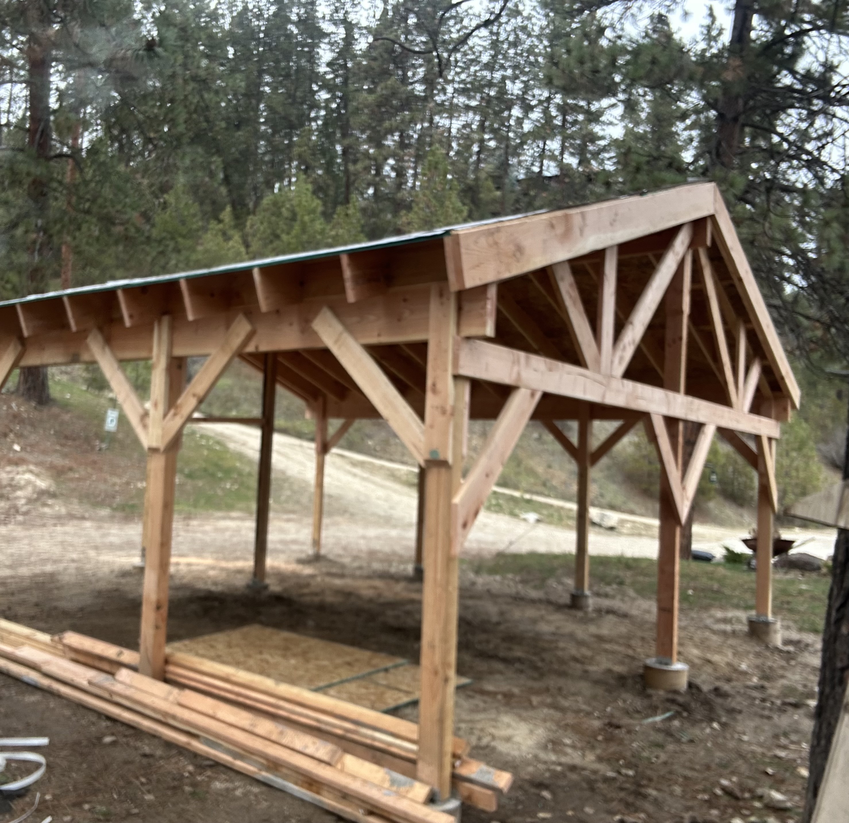 Heavy timber pavilion structure in wooded area